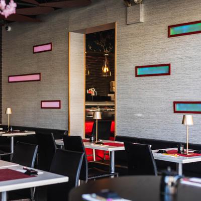 Dining room with tables, chairs and textured gray walls accented by rectangular light fixtures.