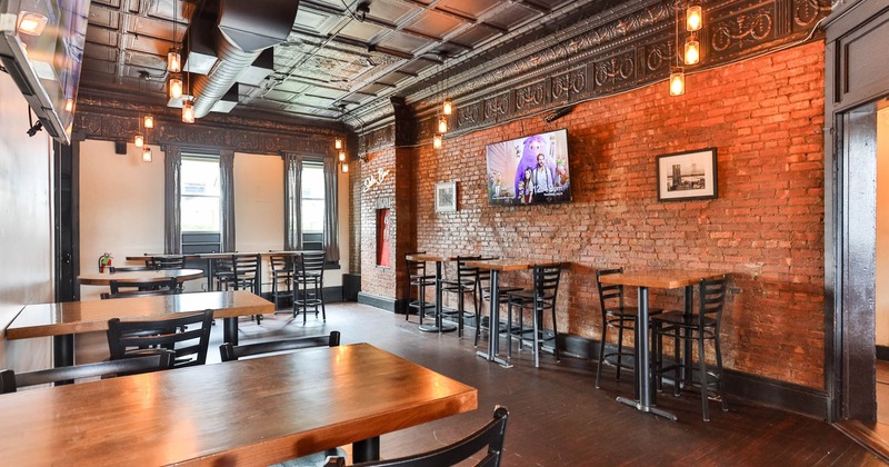 Interior, seating area, tables ready for guests, TV on the wall