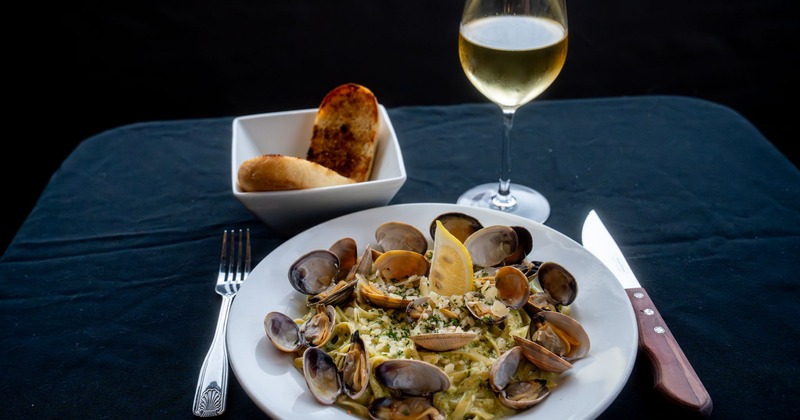 Clam pasta, served with garlic toast and a glass of white wine
