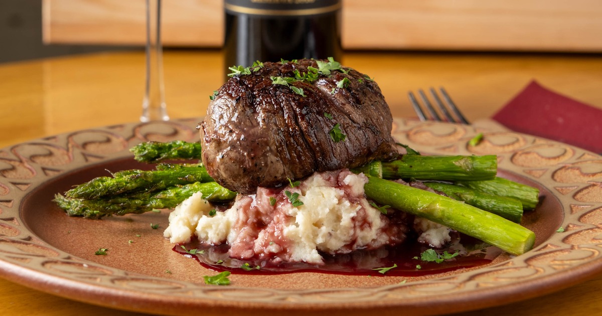 Beef filet served alongside grilled asparagus, potato pure and a red wine reduction
