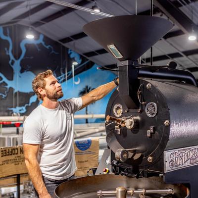Employee working the coffee roasting machine.