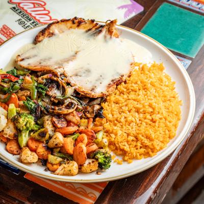 Grilled chicken breast topped with melted cheese, served with rice and sauteed veggies.