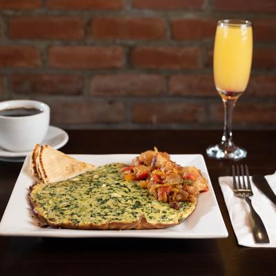 Veggie omelet plate with coffee and orange drink.