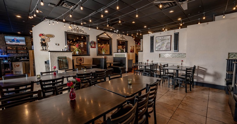 Interior with dark ceiling tiles with string lighting and traditional diner seating