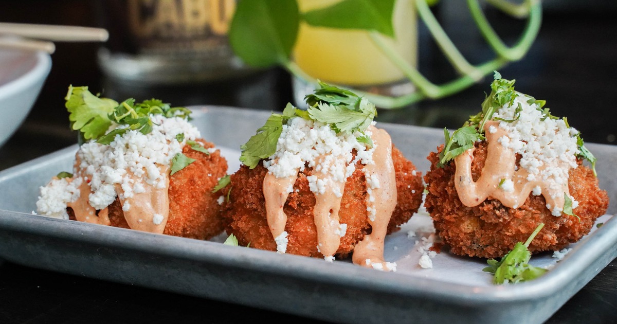 Three Elote fritters on a plate