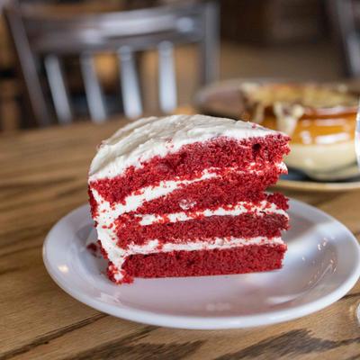 Red velvet cake slice with cream frosting.
