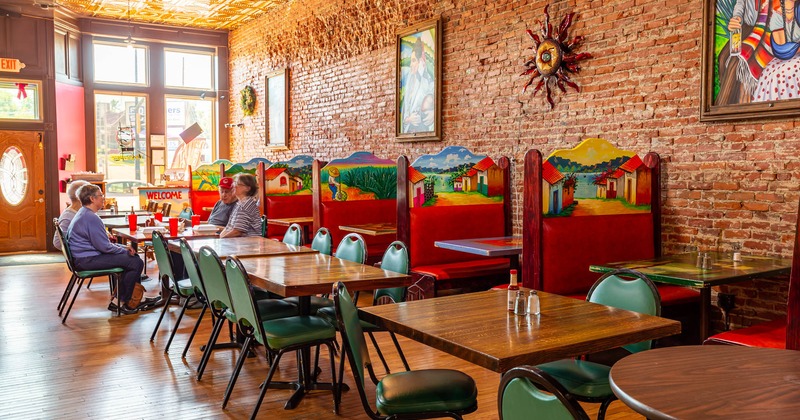 Interior, lined up dining tables and decorated restaurant booths