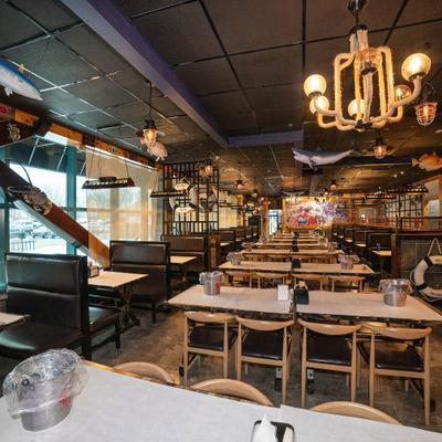 Spacious seafood restaurant interior with booths and tables.