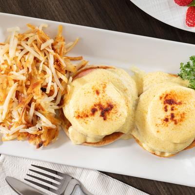 Classic Eggs Benedict served with hash browns.