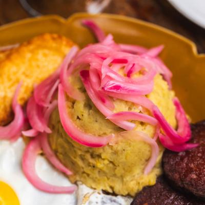 Mashed plantains on Tres Golpe dish plate, extreme close up.