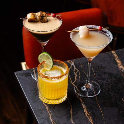 Three colorful cocktails arranged on a table.