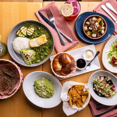 Assorted Mexican dishes and drinks on a table.