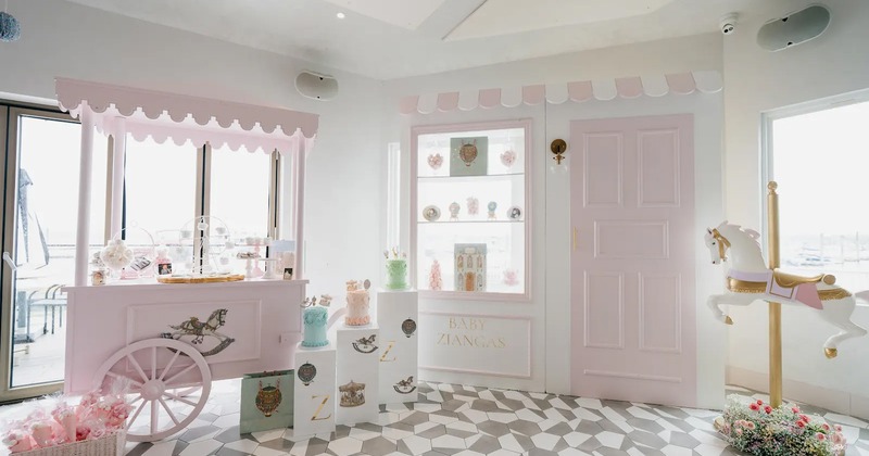 Pastel pink dessert cart and carousel horse in a bright, whimsical party setup