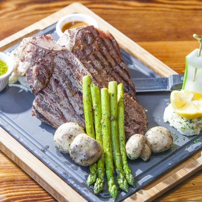 Steak with mushrooms, asparagus, and condiments.