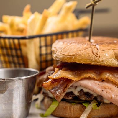 Cheeseburger served with fries, close-up.