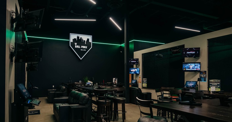 Interior, lounge area, high seating tables, two seater sofas, many TVs, bar