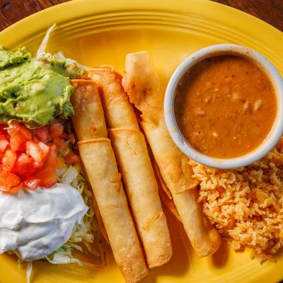 Fried tortilla rolls with rice, beans, lettuce, tomatoes, guacamole and sour cream