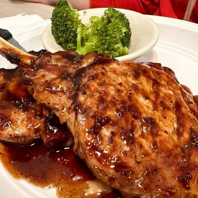 Two bone-in pork chops and a side of steamed broccoli.