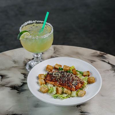 Salmon Caesar salad served with a margarita cocktail.