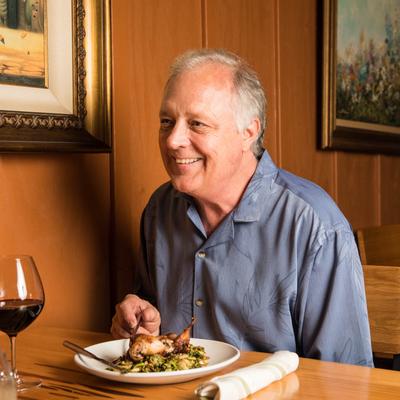 Guest eating a dish and enjoying a glass of red wine