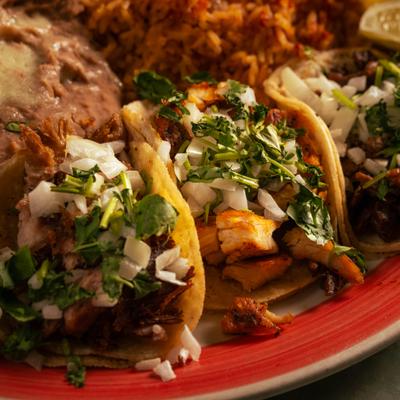 Trio Soft Tacos sserved with rice and beans, close-up.