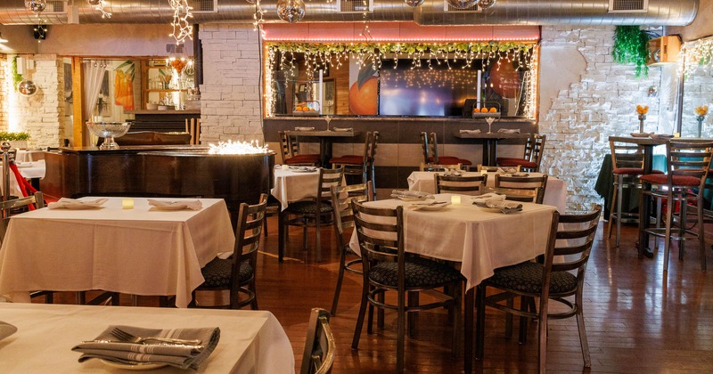 Interior, dining area, tables for two and four, high seating area in the back, stage piano