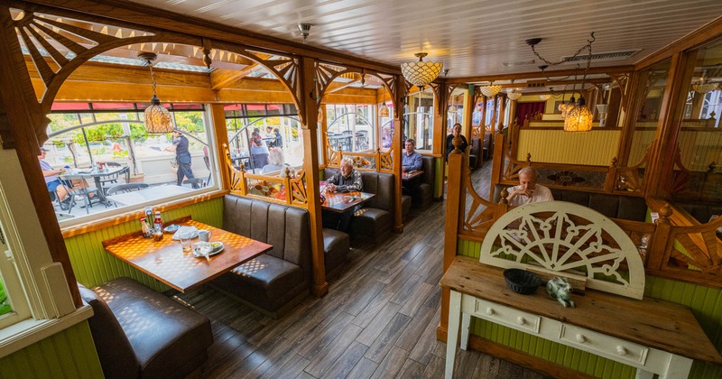 Cozy restaurant interior with wooden booths, decorative arches, and warm lighting
