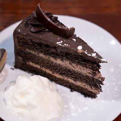 Chocolate cake slice with whipped cream garnish.
