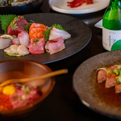 Sashimi plate with side dishes and a bottled drink.