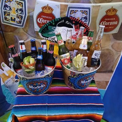 Two ice buckets with beer bottles and lime wedges on the side.