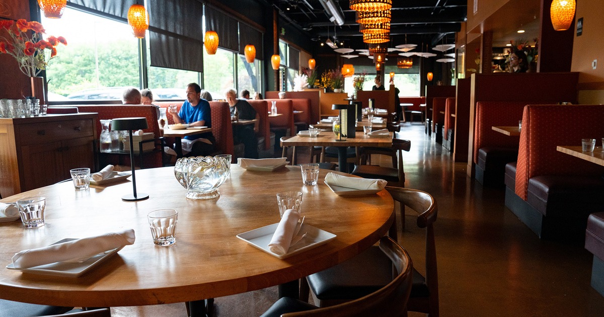 Interior dining area, round table set for guests, close up