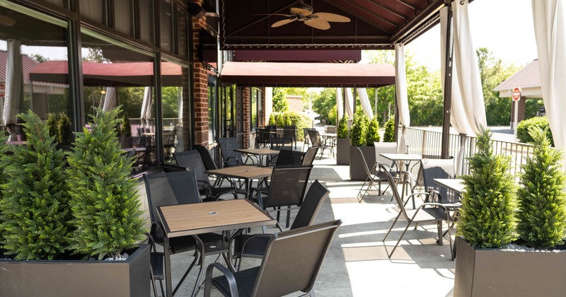 Covered exterior seating area with chairs and tables