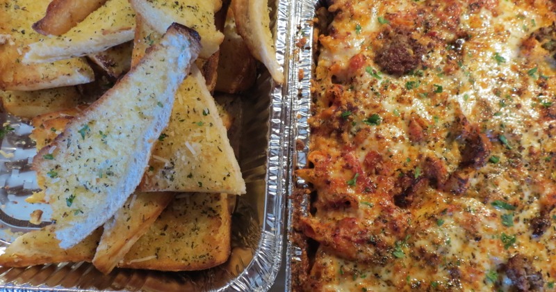 Garlic bread and baked pasta in foil trays
