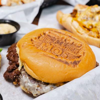 Burger severd with a sauce on the side, close-up.