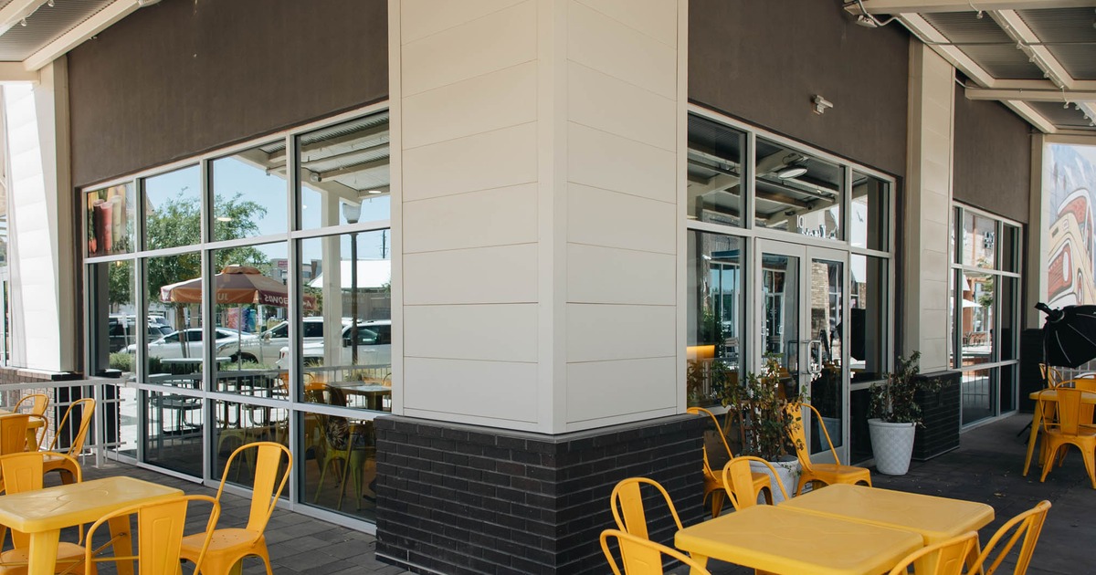 Outdoor seating featuring yellow metal chairs and tables