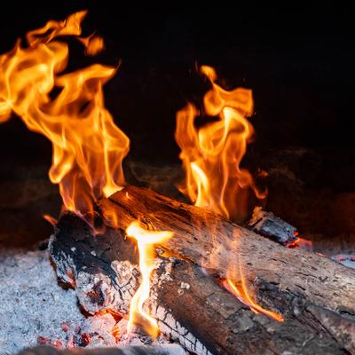 Flames engulf logs in a smoker.