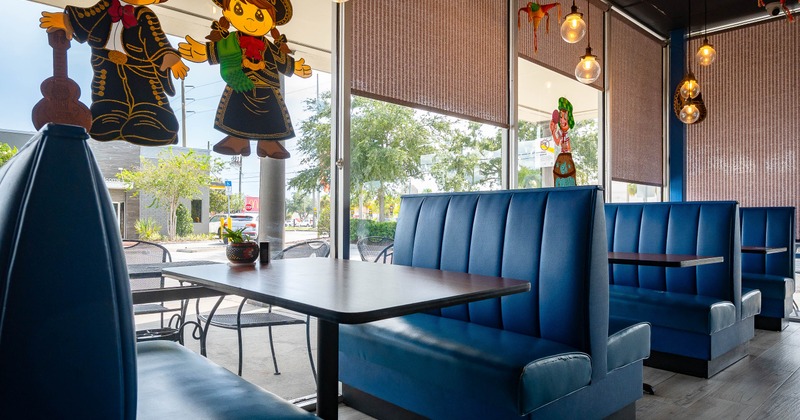 Interior - blue booths, pendant lights, large windows, a colorful Mexican-themed decorations.