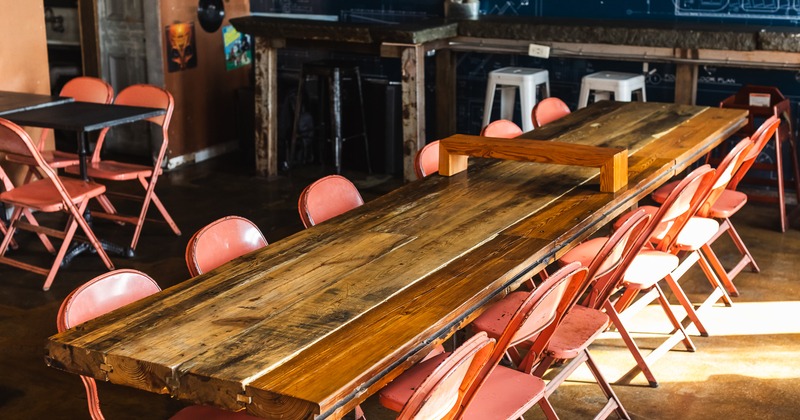 A long wooden table with folding chairs, close up