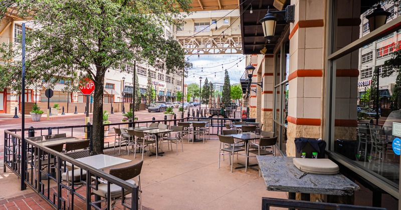 Exterior, restaurant front, patio encircled with railing, seating area, tables with chairs