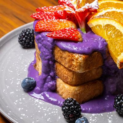 Ube French Toast garnished with fresh fruit.