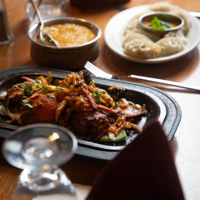 Multiple food plates on a dining table, close up.