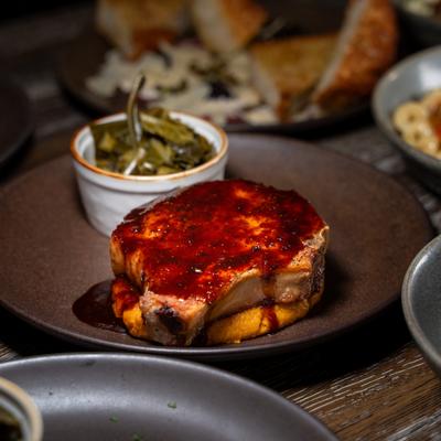 Porkchop in aplate, collard green behind.