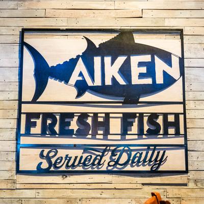 Restaurant signage on a wooden wall.