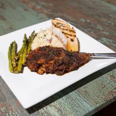 Nashville Hot Chicken served with mashed potatoes, asparagus and grilled bread.