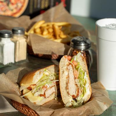 Chicken Caesar Wrap on a table with fries and condiments.
