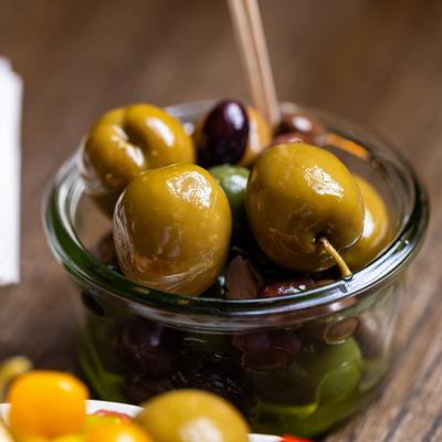 Mixed olives in a small glass bowl.