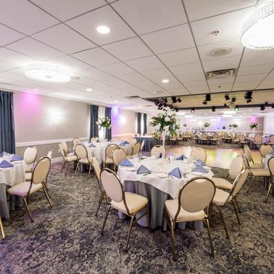 Banquet hall featuring white-clothed tables with floral centerpieces.