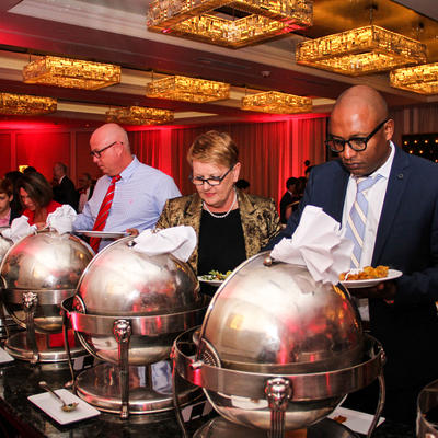 A row of people by the catering table