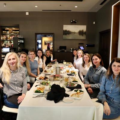 Large group of people gathered for a meal in a restaurant setting.