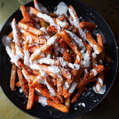 Chili truffle fries topped with cotija cheese and jerk aioli.